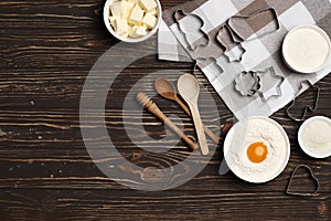 Baking utensils and ingredients. rolling pin, cookie mold,.Â cupcake cases and sugar sprinkling on a wooden background.